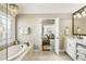 A luxurious ensuite bath featuring a freestanding soaking tub and decorative leaded glass window at 4235 Iron Duke Ct, Peachtree Corners, GA 30097