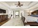 Main bedroom showcasing a ceiling fan, hardwood floors, and access to ensuite bathroom at 4235 Iron Duke Ct, Peachtree Corners, GA 30097