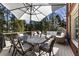 Relaxing outdoor patio featuring stylish furniture, an umbrella, and a view of the lush backyard at 4235 Iron Duke Ct, Peachtree Corners, GA 30097
