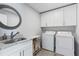 This laundry room includes a granite sink, storage cabinets, washer, and dryer at 4160 Tilly Mill Rd, Atlanta, GA 30360