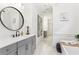 Bright bathroom featuring a long vanity, stylish mirror, and a glimpse of the soaking tub at 4308 Southside Dr, Acworth, GA 30101