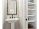 Elegant powder room with pedestal sink and decorative mirror, next to built-in storage shelves at 4308 Southside Dr, Acworth, GA 30101