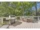 Deck with a grill and a dining table, surrounded by lush greenery at 4742 Balmoral Ne Way, Marietta, GA 30068