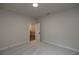 Bedroom featuring carpet flooring, neutral walls, and access to the hallway at 133 Ward'S Crossing Way # 18, Johns Creek, GA 30022