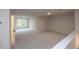 Spacious bonus room featuring neutral walls, carpet, and a window for natural light at 133 Ward'S Crossing Way # 18, Johns Creek, GA 30022
