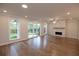 Spacious living room featuring a fireplace, large windows and sliding glass doors to the outdoor patio at 133 Ward'S Crossing Way # 18, Johns Creek, GA 30022