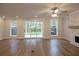 Open-concept living room with hardwood floors, fireplace, and access to the outdoor patio at 133 Ward'S Crossing Way # 18, Johns Creek, GA 30022