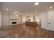 Spacious living room featuring hardwood floors, a modern fireplace, and an open layout to the kitchen at 133 Ward'S Crossing Way # 18, Johns Creek, GA 30022