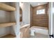 Modern bathroom features a bathtub, wood-style tiles, and open wood shelving at 145 Cedarwood Ln, Roswell, GA 30075