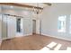 Bright bedroom boasts beamed ceilings, a modern chandelier, and a sliding barn door to the en-suite bathroom at 145 Cedarwood Ln, Roswell, GA 30075