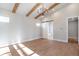 Spacious bedroom features vaulted ceilings with wood beams and a sliding barn door leading to a luxurious bathroom at 145 Cedarwood Ln, Roswell, GA 30075