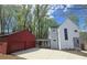 Striking exterior showcasing modern design, a red detached two-car garage, and a walkway to the house in a wooded setting at 145 Cedarwood Ln, Roswell, GA 30075