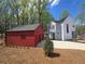 Modern two-story home with gray siding, black frame windows, red garage, and beautiful surrounding trees and nature at 145 Cedarwood Ln, Roswell, GA 30075