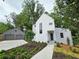 Modern exterior with white siding, black-framed windows, manicured landscaping, and two-car garage at 145 Cedarwood Ln, Roswell, GA 30075