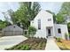 Beautiful modern home with white exterior, tidy landscaping, and a two-car detached garage at 145 Cedarwood Ln, Roswell, GA 30075