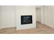 Close-up of the modern fireplace with a textured surround and wood-look floors at 145 Cedarwood Ln, Roswell, GA 30075