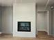 Living room with a modern fireplace, light gray walls, and light-colored wood floors at 145 Cedarwood Ln, Roswell, GA 30075