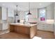 Bright kitchen with an island, white cabinets, and pendant lights at 145 Cedarwood Ln, Roswell, GA 30075