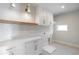 White laundry room features wooden shelving, white cabinets, and under cabinet lighting at 145 Cedarwood Ln, Roswell, GA 30075