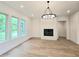 Modern living room with a fireplace, large windows, and a statement chandelier at 145 Cedarwood Ln, Roswell, GA 30075