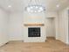 Bright living room with modern fireplace, wood mantel, and stylish chandelier at 145 Cedarwood Ln, Roswell, GA 30075