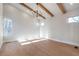Open living room features vaulted ceilings, wooden beams, modern chandelier, and large windows providing natural light at 145 Cedarwood Ln, Roswell, GA 30075