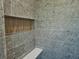 Shower featuring gray tile, built-in bench, and recessed niche at 145 Cedarwood Ln, Roswell, GA 30075