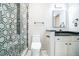 Stylish bathroom featuring modern fixtures, a glass shower and a sleek black granite countertop at 1490 Fair Point Pass, Suwanee, GA 30024