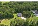 An aerial view of a single-story home nestled amongst lush green trees on a large lot at 25 Horseshoe Ct, Covington, GA 30014