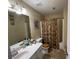 Neutral toned bathroom with a shower-tub combo, framed mirror, and floral shower curtain at 25 Horseshoe Ct, Covington, GA 30014