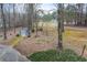 Backyard shed featuring light-colored walls, double doors, a well-kept lawn, brick landscaping, and surrounded by tall trees at 1980 Two Springs Way, Lawrenceville, GA 30043