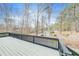 Backyard view from the wood deck, featuring a black railing with a shed in the background with wooded scenery at 1980 Two Springs Way, Lawrenceville, GA 30043