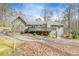 Back of the home features a large outdoor deck, lower patio, and ample parking surrounded by mature trees at 1980 Two Springs Way, Lawrenceville, GA 30043
