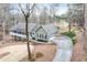 Angle view of the exterior displaying the garage, driveway, and surrounding natural wooded landscape at 1980 Two Springs Way, Lawrenceville, GA 30043