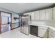 Open kitchen boasts stainless steel appliances, white cabinets and tile backsplash at 1980 Two Springs Way, Lawrenceville, GA 30043