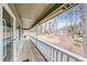 Spacious covered porch with white railing overlooking the front yard and wooded landscape at 1980 Two Springs Way, Lawrenceville, GA 30043