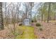 Backyard shed featuring light-colored walls, double doors, a well-kept lawn, and brick landscaping at 1980 Two Springs Way, Lawrenceville, GA 30043