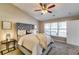 Comfortable main bedroom features a plush bed, a ceiling fan, and a large sunny window at 2139 Hickory Se Bnd # E, Conyers, GA 30013