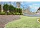 A serene backyard featuring lush green grass, manicured hedges, and a classic wooden fence offers a private outdoor retreat at 2964 Perimeter Cir, Buford, GA 30519