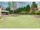 Well-maintained backyard with lush green grass, mature trees, privacy landscaping, and view of the screened in porch at 2964 Perimeter Cir, Buford, GA 30519