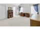 Spacious bedroom with a decorative cabinet, large desk, natural light from two windows, and neutral-toned carpet at 2964 Perimeter Cir, Buford, GA 30519