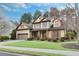 An appealing two-story house with a manicured lawn, complemented by blossoming trees, creating a serene atmosphere at 2964 Perimeter Cir, Buford, GA 30519