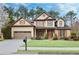 Beautiful two-story home featuring manicured lawn, complemented by a two car garage, and colorful landscaping at 2964 Perimeter Cir, Buford, GA 30519