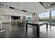 Upscale game room boasts a pool table, bar seating, dining area, and expansive windows with a serene outdoor view at 361 17Th St # 2122, Atlanta, GA 30363