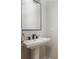 Stylish powder room featuring a modern pedestal sink, sleek black faucet, and minimalist mirror frame at 906 Bingham St, Woodstock, GA 30188