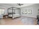 Spacious bedroom with a modern four-poster bed, light wood floors, and natural light from multiple windows at 906 Bingham St, Woodstock, GA 30188