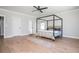 Spacious bedroom featuring light wood floors, a minimalist four-poster bed, and an ensuite bathroom at 906 Bingham St, Woodstock, GA 30188