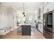 View of the kitchen leading to the dining area, featuring a functional island and stainless appliances at 906 Bingham St, Woodstock, GA 30188