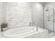 Luxurious bathroom features a soaking tub with decorative tile accent wall and a glass-enclosed shower with marble tiling at 223 16Th Nw St # 2, Atlanta, GA 30363