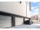 Three-car garages featuring white garage doors and a black vehicle in modern apartment complex at 223 16Th Nw St # 2, Atlanta, GA 30363